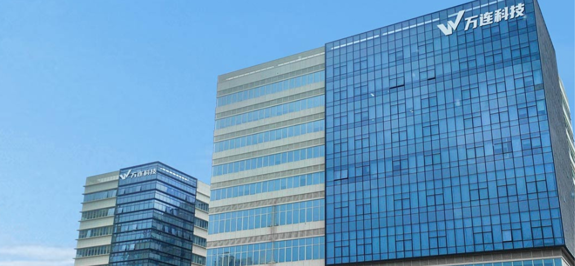 Modern office space with blue lighting, dark atmosphere, computer workstations with monitors, and glass walls